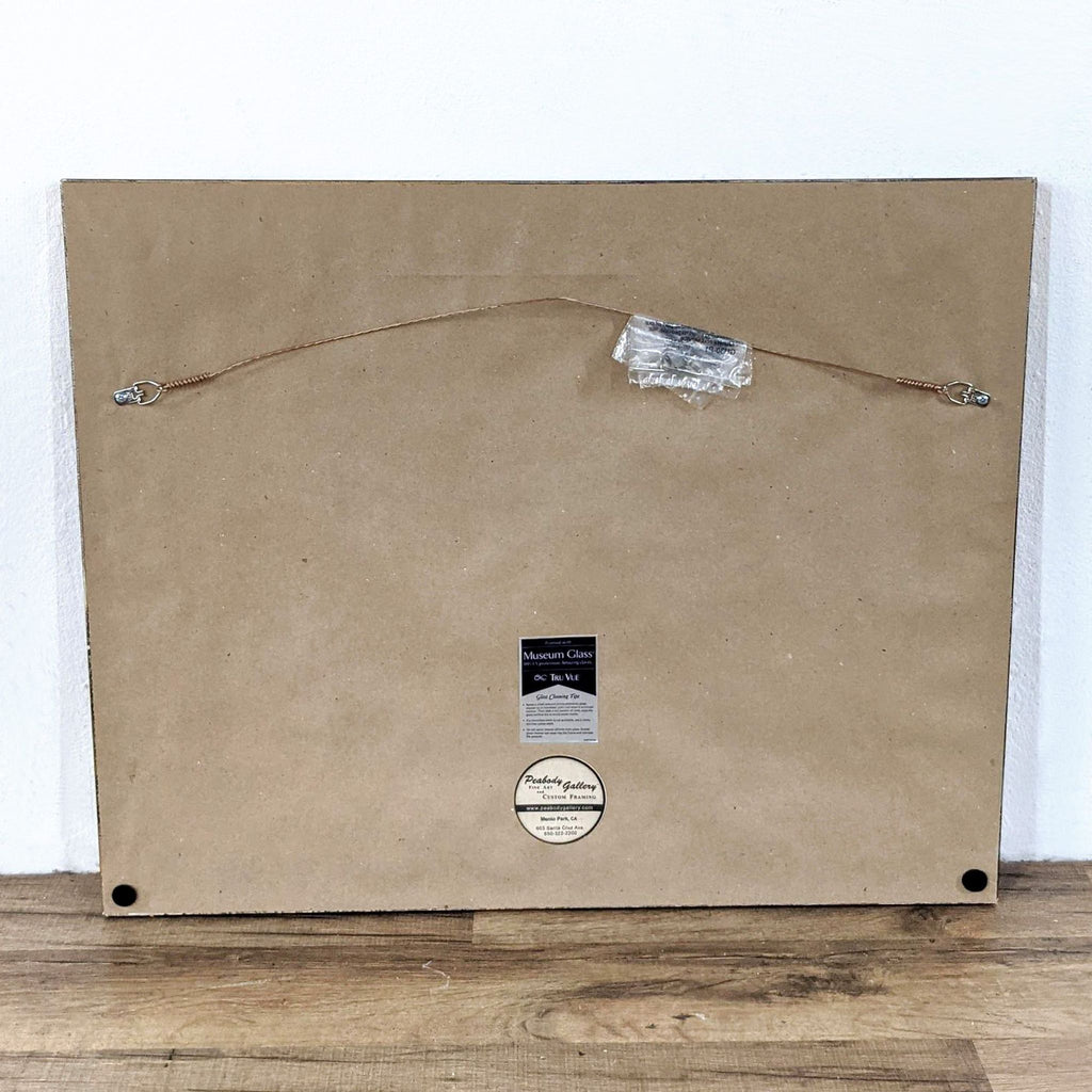 3. Back of the framed artwork with hanging wire, labels from Peabody Gallery Custom Framing, and Museum Glass.