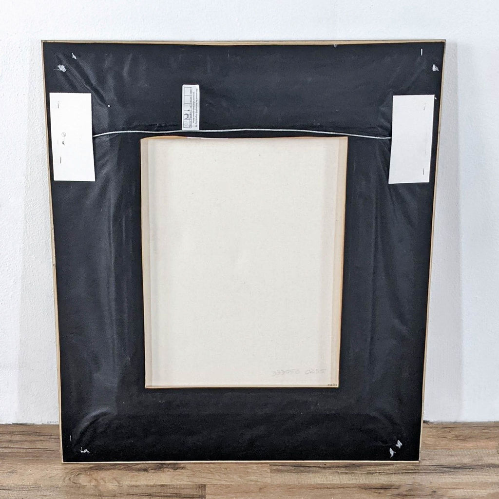 The back of a framed canvas print “Key of G” by Michael Godard, showing hanging wire and labels.