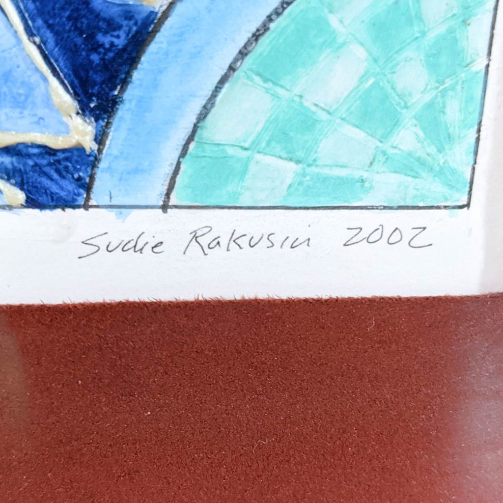 2. Close-up of bottom corner showing the handwritten signature “Sudie Rakusin 2002” on the bright abstract art.