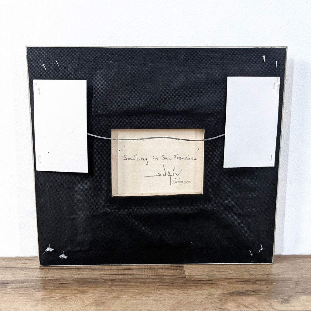 The back of a framed Reperch artwork titled "Sailing in San Francisco" is shown, with hanging wire attached.