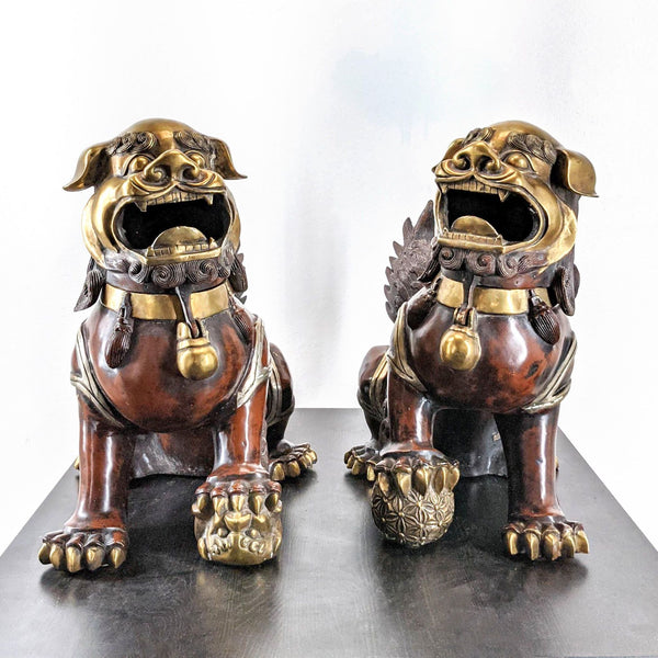 Pair of Reperch brand metal Foo Dog guardian statues, one male and one female, with symbolic protective features.