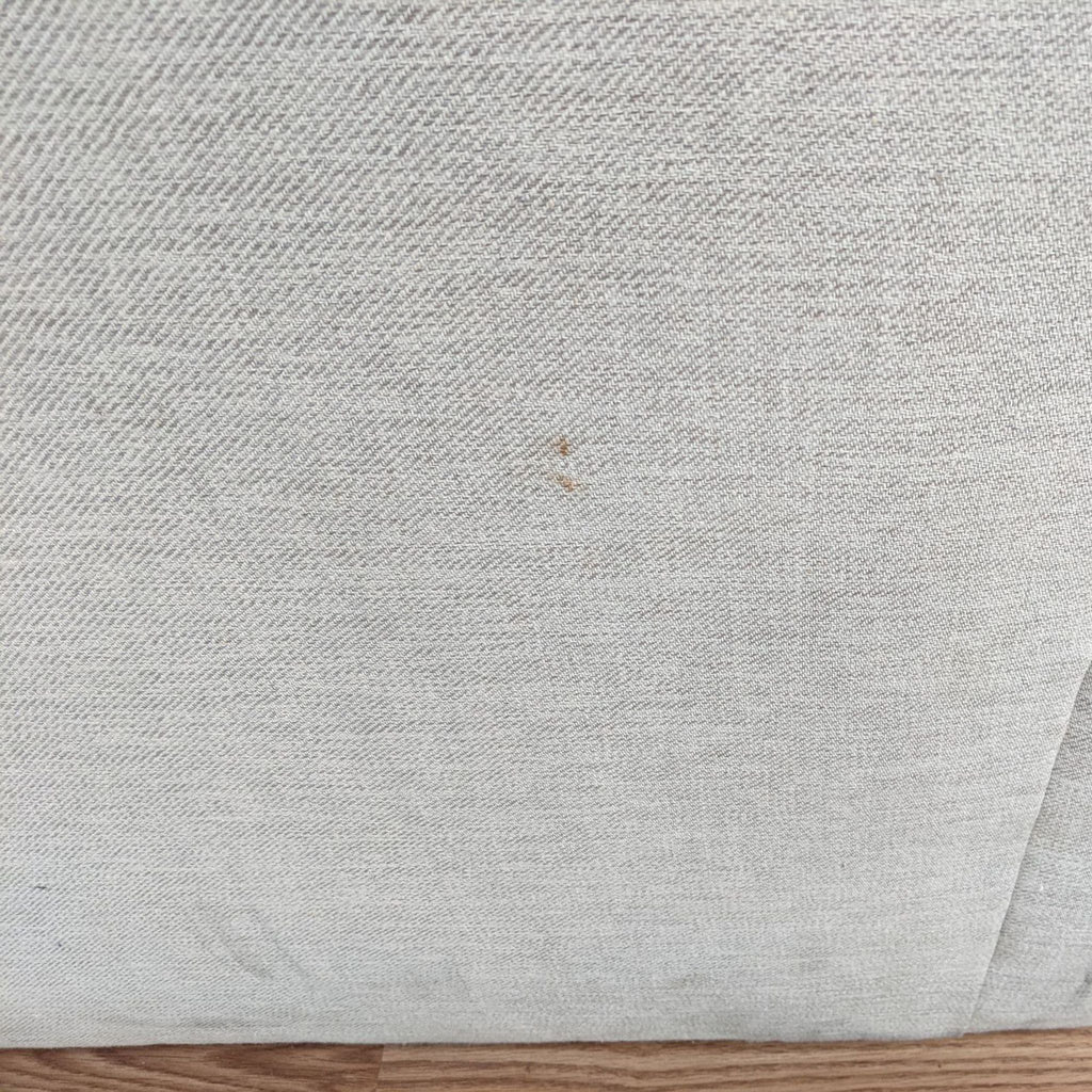 Light-colored Pottery Barn lounge fabric with a small stain, needing cleaning.